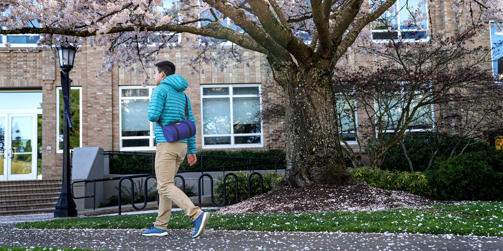 Man walking along park path with a shoulder bag | North St Bags