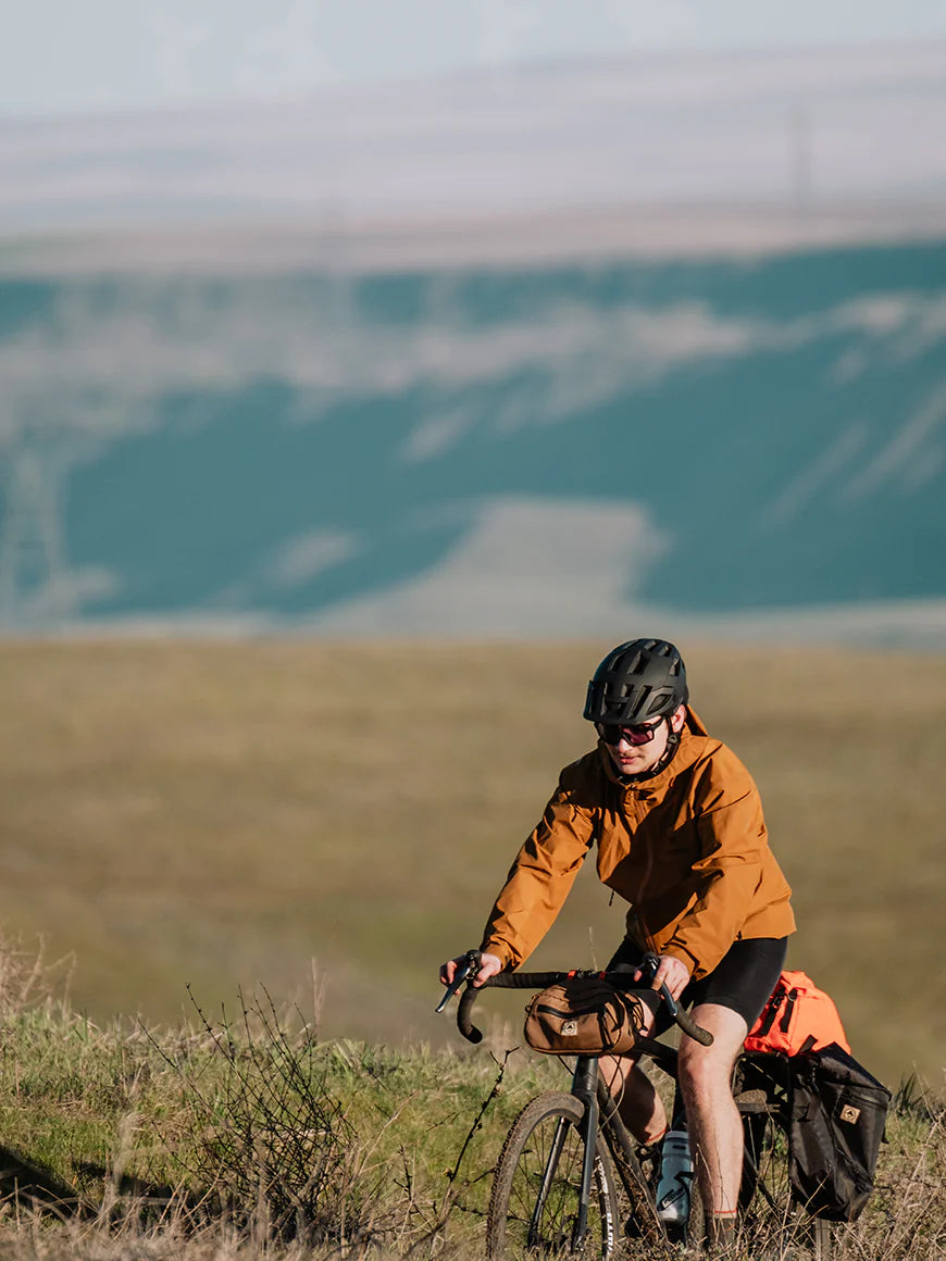 Cyclist on a hillside with bikepacking bags. - North St Bags all-groups