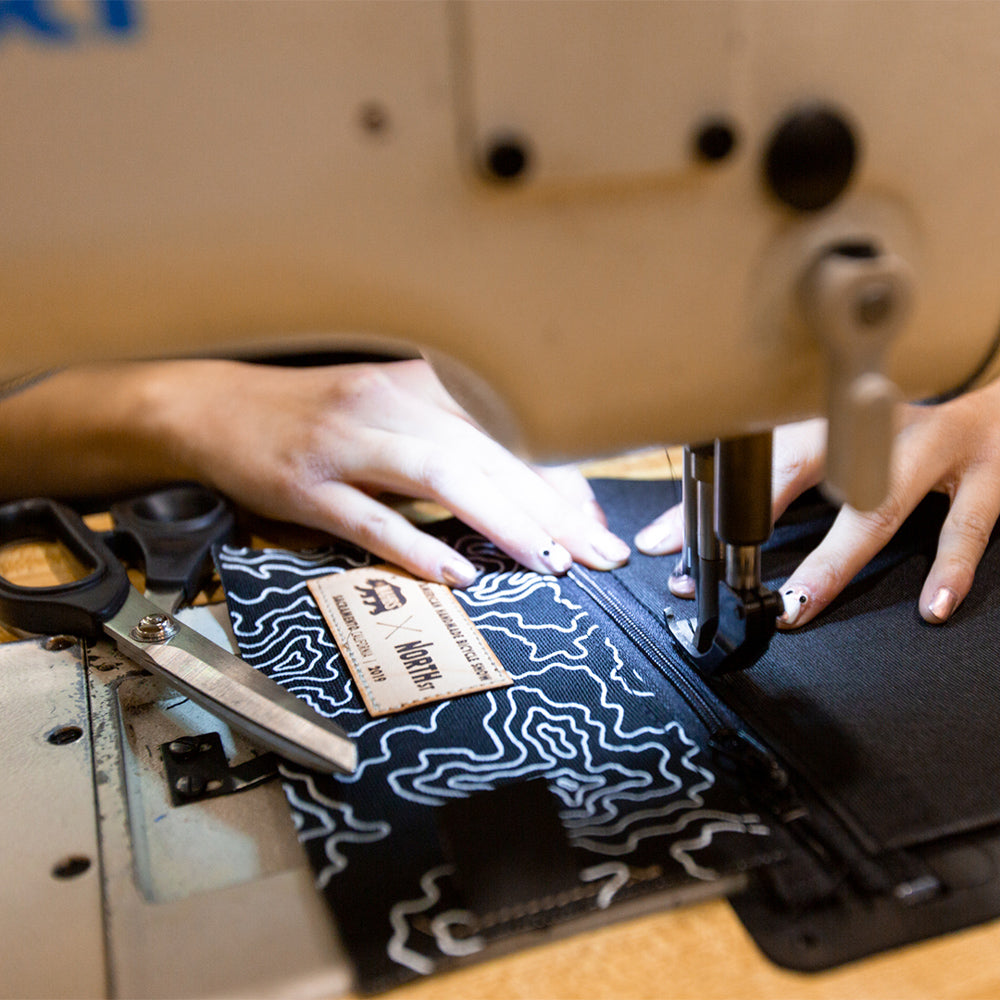 Production worker sews a pouch at a machine at North Street Bags 