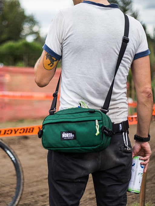 Guy at a bike race wearing a Pioneer 12 Pack with a shoulder strap. - North St. Bags