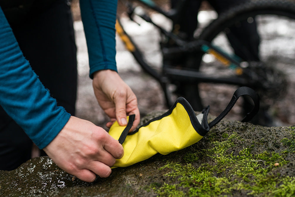 Hands rolling up a tool roll and stowing it.  - North St. Bags all-groups