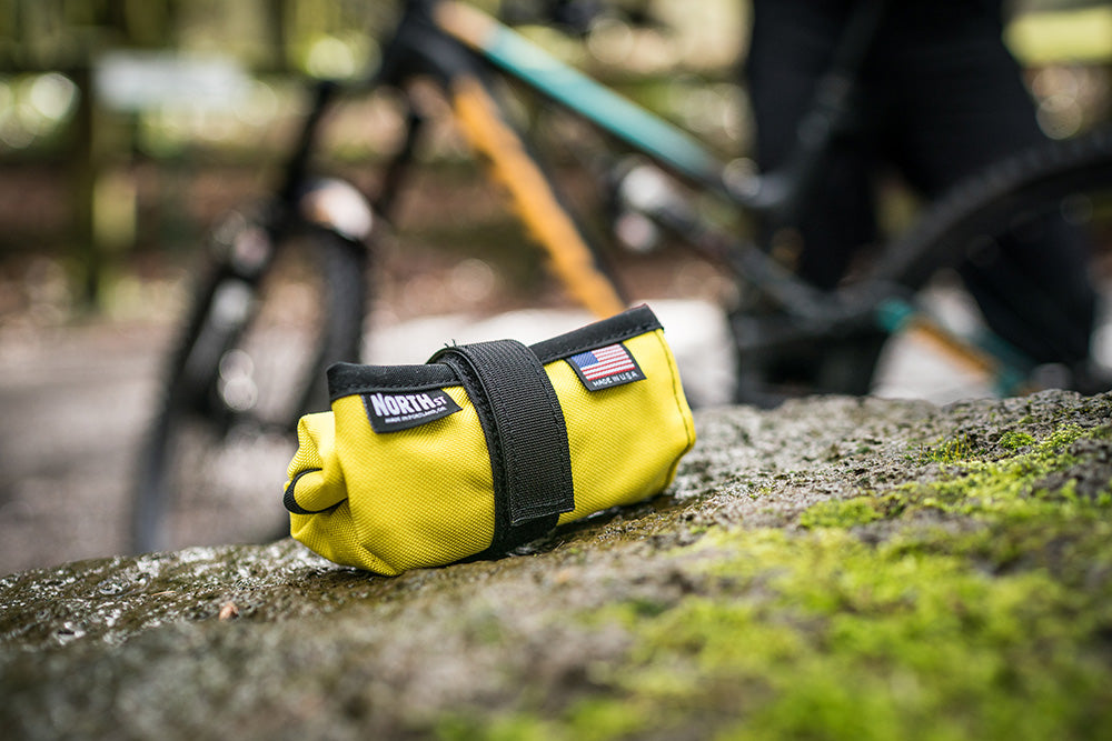 Yellow Tool Roll on a rock next to a trail.  - North St. Bags all-groups