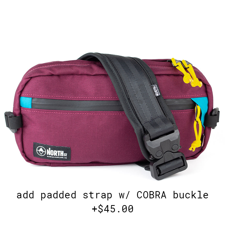 front view of Eliot Sling Pack with COBRA buckle strap in burgundy & Teal