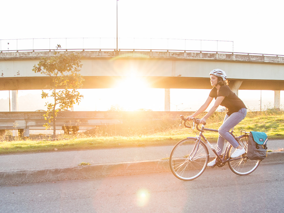 Female cyclist riding bike along a road with a Morrison Backpack Pannier w/ EcoPak - North St. Bags all-groups