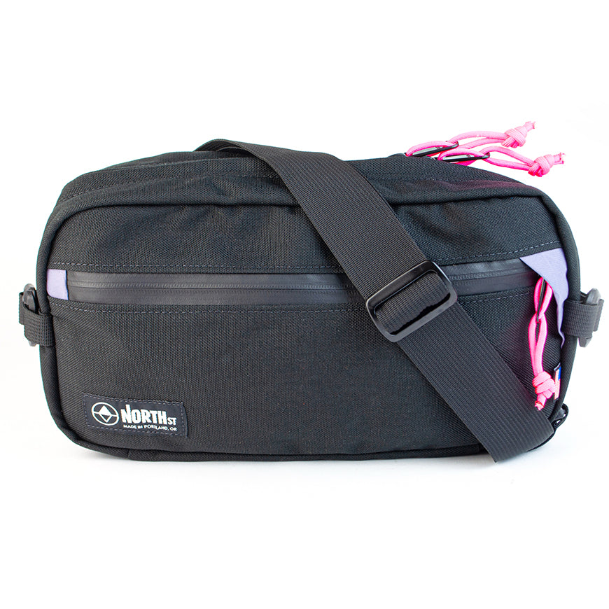 front view of sling pack by North St in black and plum