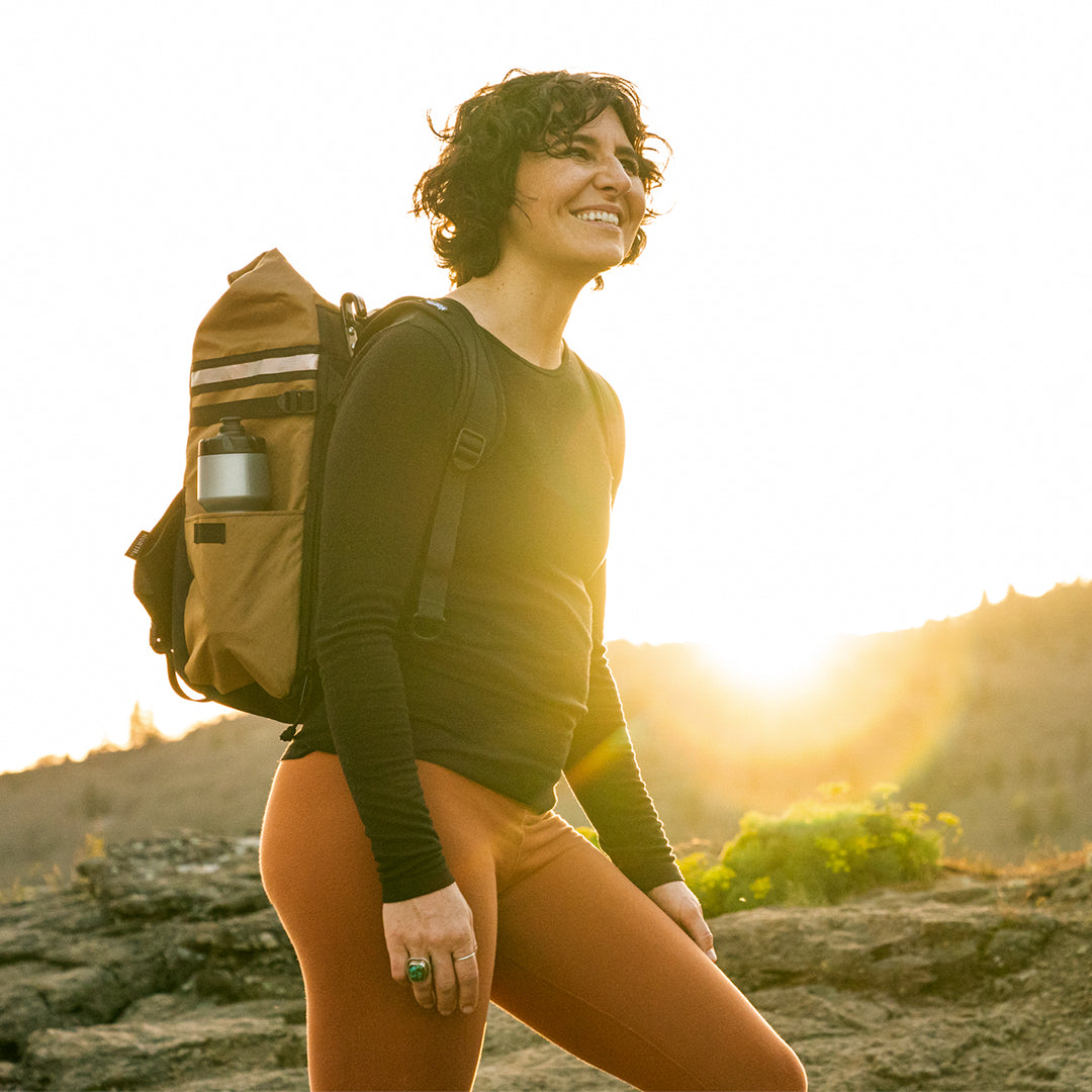 Woman wearing backpack pannier as a backpack on a hiking trail. - North St. Bags all-groups