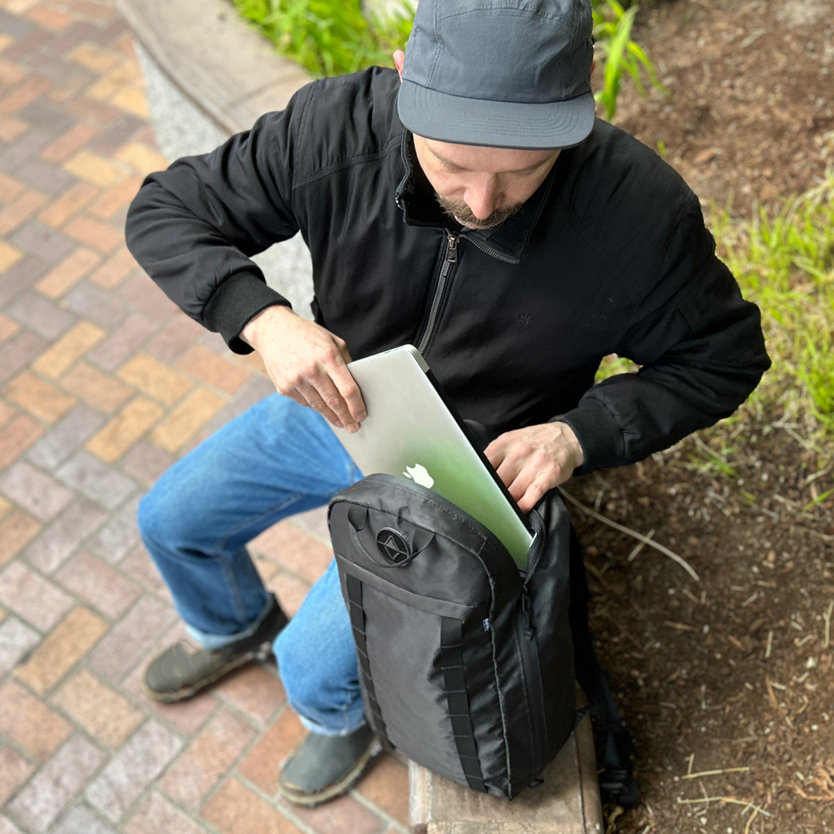 Guy packing a laptop into a Vancouver Daypack - North St. Bags all-groups