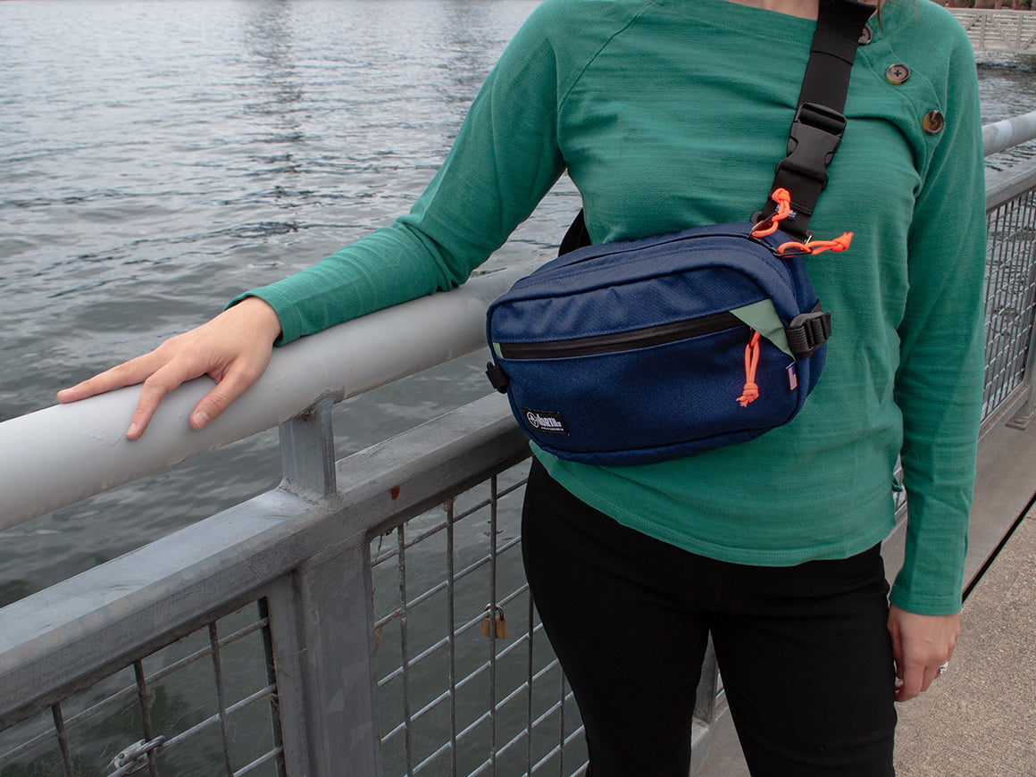 woman at waterfont wearing sling pack all-groups